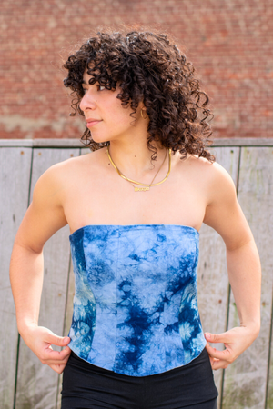 Woman wearing a Latin-inspired, blue tie-dye strapless corset top, hand-dyed in El Salvador